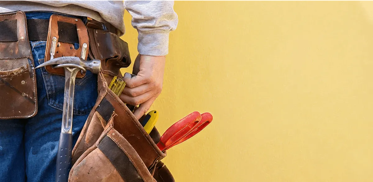 Handyman with tool belt ready for home repairs and maintenance in Huntsville, AL