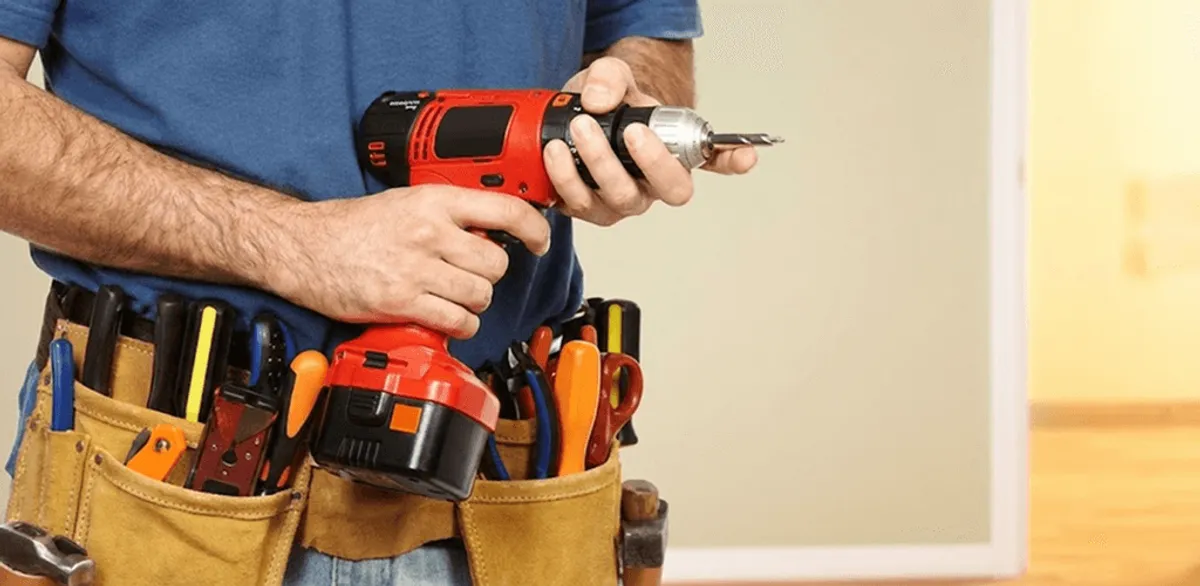 Handyman holding a power drill for home repairs and installations in Huntsville, AL